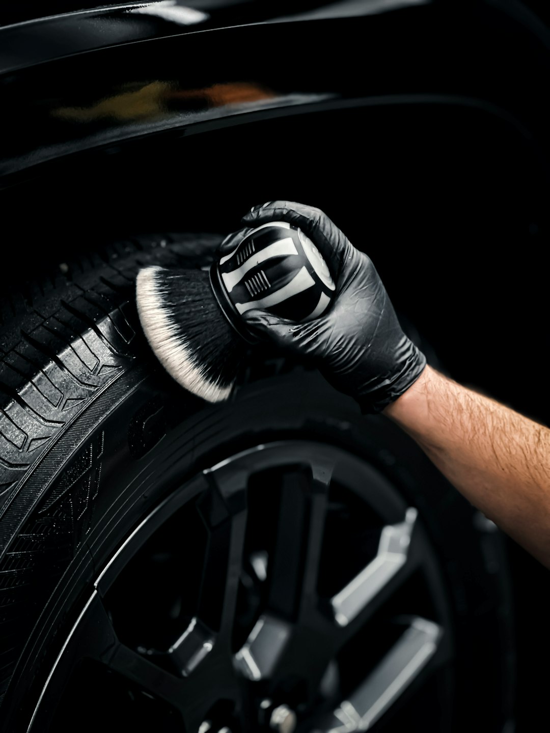 services-04 a-man-with-a-glove-on-his-hand-is-changing-the-tire-of-a-car-8k-t1ewtyss